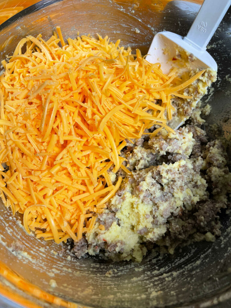 Keto Sausage and Cheese Mini Muffin adding shredded cheese